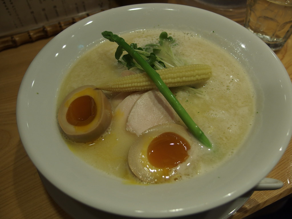 白いスープに鶏肉、味玉、ヤングコーン、アスパラガスをのせた鶏白湯ラーメン
