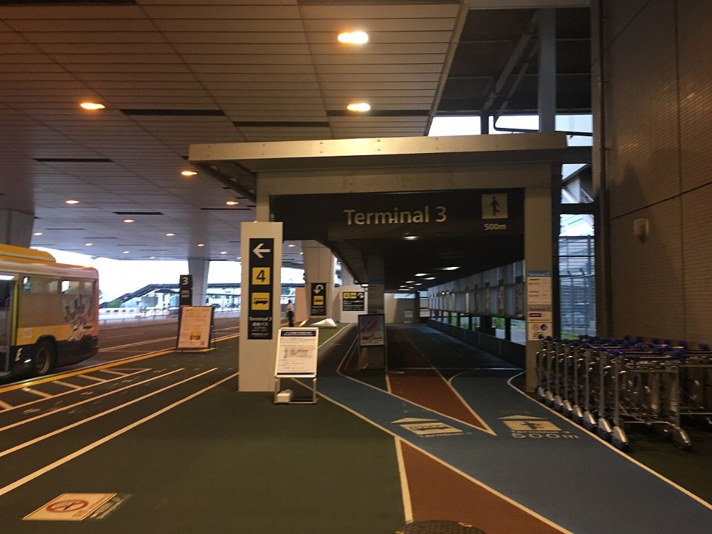 A covered walkway to Narita Airport Terminal 3 with a Terminal 3 sign