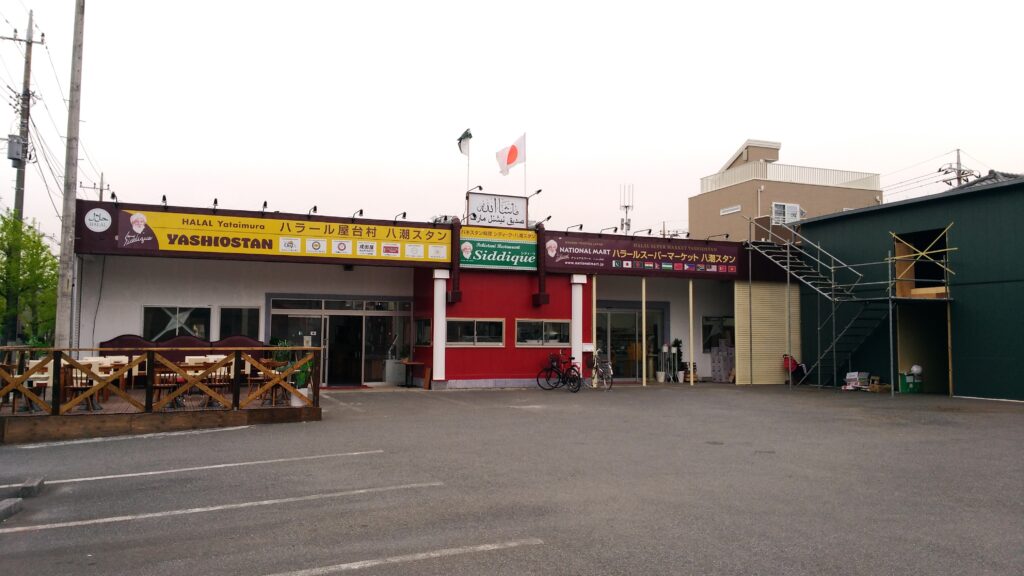 Exterior of National Mart & Halal Yataimura Yashiostan, with signs for a halal supermarket and restaurants